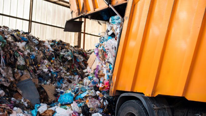 An garbage truck unloading garbage at waste sorting plant